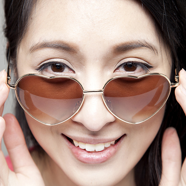 Beautiful Asian girl with heart-shaped sunglasses