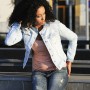 Young black woman wearing a denim jacket in urban background