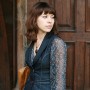 The girl in a vest at a wooden gate.