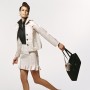 Portrait of a Well Dressed Woman Wearing Clothes made from Paper and Swinging a Handbag