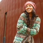 A beautiful natural looking model poses in a crocheted sweater